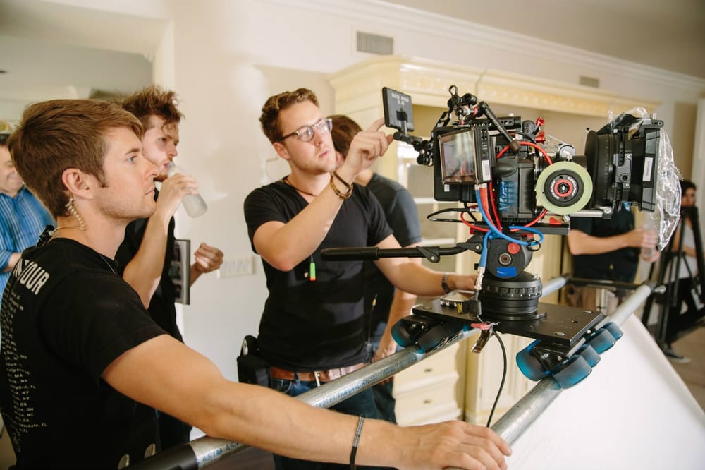 4 men setting up a camera on a dolly during a commercial shoot